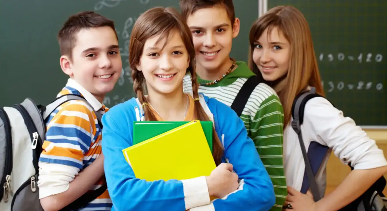 A diverse group of friendly secondary school students ready for class with their books and backpacks.